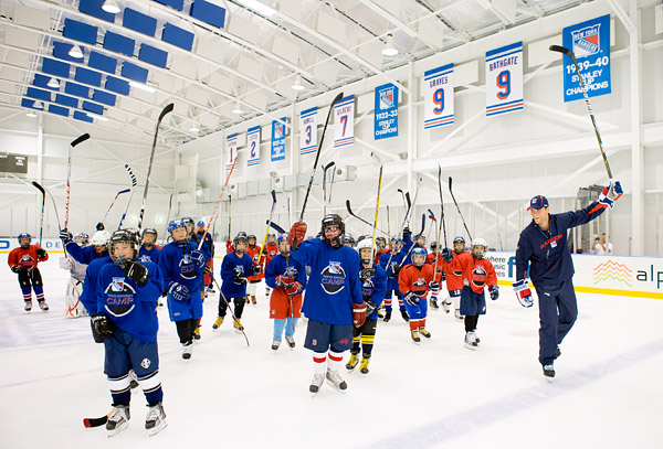Michael Sauer leads a hockey camp stick salute